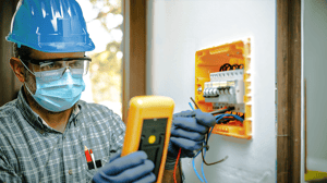 Contractor with with white helmet and vest showing the property under construction to engineer and architect