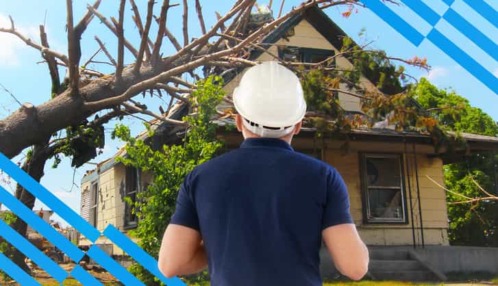 Restoration contractor in a CAT job in front of a house affected by a Natural disaster, destroyed by a tree 