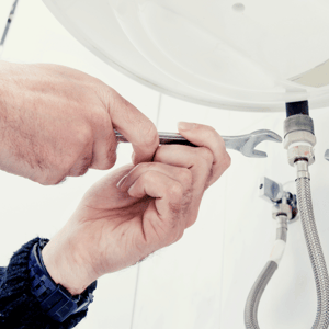 Plumber fixing a sink with water leak