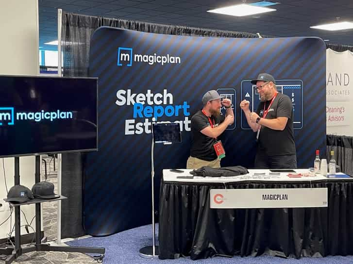 magicpla booth at tradeshow with tv screen and Allan Sales Director and Josh Winton from Discreet Restoration